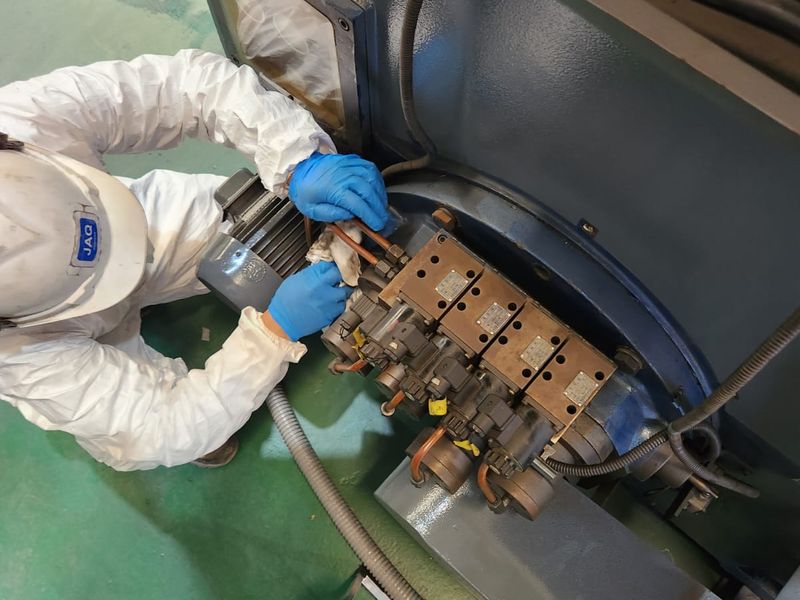 Técnico de JAQ reparando el sistema hidráulico de un torno vertical
